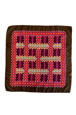 Interwoven zigzag “pixel” print scarf in shades of red, pink, orange, brown, turquoise and yellow.