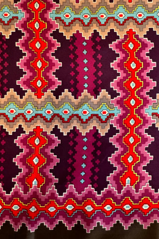 Interwoven zigzag “pixel” print scarf in shades of red, pink, orange, brown, turquoise and yellow.