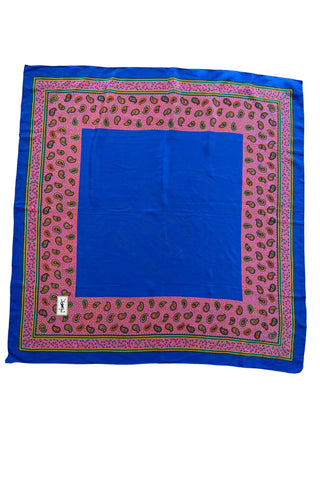 Royal blue vintage Yves Saint-Laurent silk scarf with wide pink paisley print border in shades of red, green, and yellow. Beautifully hand-finished with a rolled edge hem.