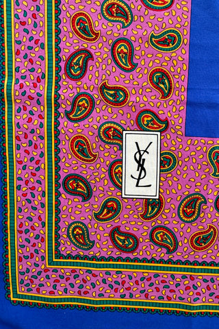 Royal blue vintage Yves Saint-Laurent silk scarf with wide pink paisley print border in shades of red, green, and yellow. Beautifully hand-finished with a rolled edge hem.