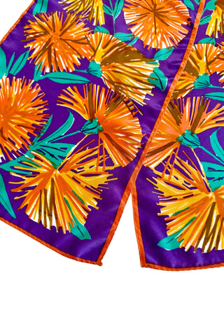 Long, rectangular vintage silk scarf by Vera, with royal purple background and bold orange and green dandelion print. 