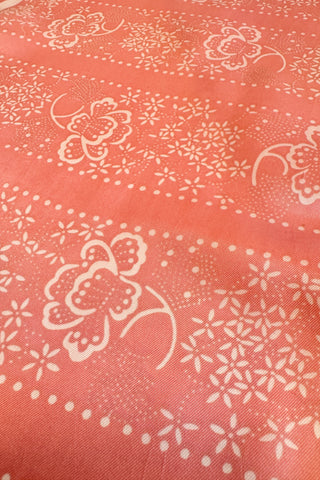 Long salmon pink vintage scarf with light pink border and floral print.