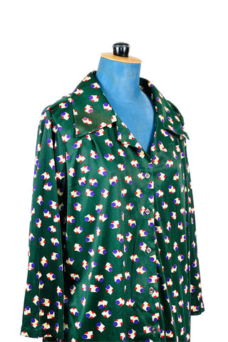 Deep emerald green vintage 1970s button down shirt with pointed collar and three-quarter length sleeves. The nylon polyester fabric features a geometric pattern with white, yellow, and red squares with purple circles.