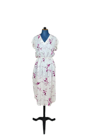 Vintage 1970s V-neck dress of soft woven rayon with an elegant botanical print in magenta and fuchsia. Adorable button trim down both sides of the skirt, with a curved hem. The waist is elasticized, giving a “blouson” effect to the bodice. Includes a matching sash belt.