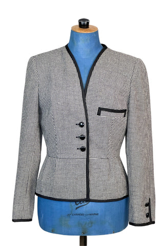 Super-chic nipped waist vintage 1970s blazer in black and white houndstooth wool. Designed by Lily Simon, who was a fixture of Montreal fashion in the 1950s, 1960s and 1970s with her famous store on Saint-Laurent Boulevard. Originally, the shop curated a collection of high-end clothing from local designers, then eventually expanded to sell internationally renowned couture brands. This blazer is from Lily Simon’s own couture-quality collection.