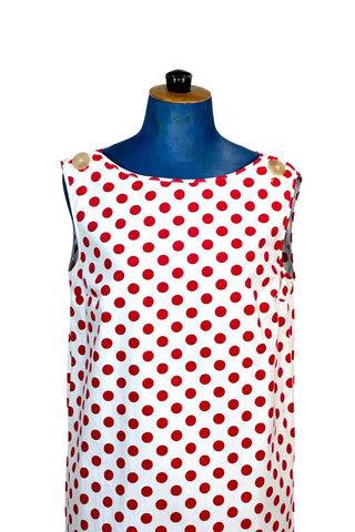 Vintage 1960s polka dot dress in 100% cotton. The plain weave cotton features a large red polka dot print on a white background. Oversized buttons at the shoulder add to the whimsy of this fun mod dress. Wear belted for a more fitted look, or unbelted to frolic, wild and free.