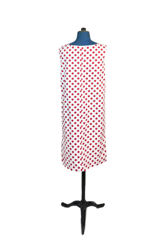 Vintage 1960s polka dot dress in 100% cotton. The plain weave cotton features a large red polka dot print on a white background. Oversized buttons at the shoulder add to the whimsy of this fun mod dress. Wear belted for a more fitted look, or unbelted to frolic, wild and free.