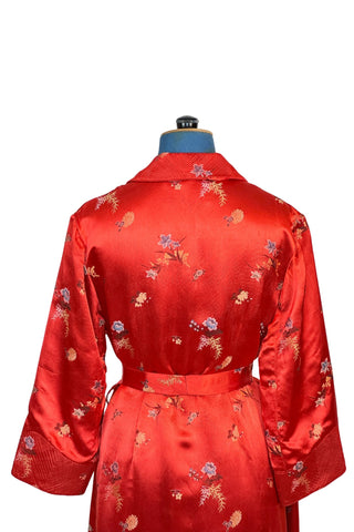 Vintage 1950s robe in rich, heavy rayon Chinese brocade. The collar, cuffs, and pockets are intricately quilted, which adds beautiful structure and weight in those areas. Closes in the front with two frog closures, and ties with a matching sash belt. Fully lined in silky red rayon.  