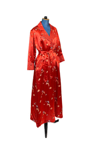 Vintage 1950s robe in rich, heavy rayon Chinese brocade. The collar, cuffs, and pockets are intricately quilted, which adds beautiful structure and weight in those areas. Closes in the front with two frog closures, and ties with a matching sash belt. Fully lined in silky red rayon.  