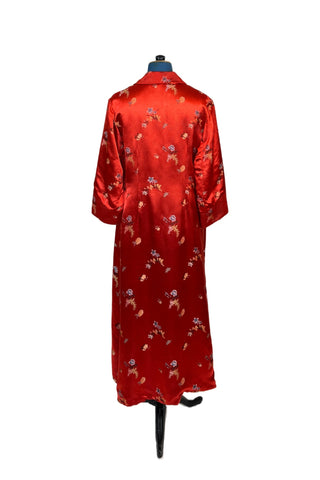 Vintage 1950s robe in rich, heavy rayon Chinese brocade. The collar, cuffs, and pockets are intricately quilted, which adds beautiful structure and weight in those areas. Closes in the front with two frog closures, and ties with a matching sash belt. Fully lined in silky red rayon.  