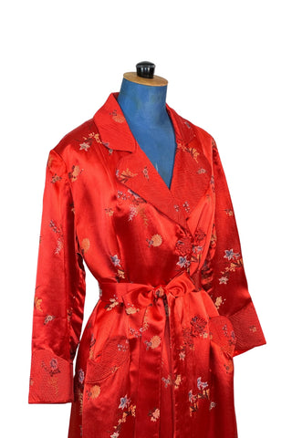 Vintage 1950s robe in rich, heavy rayon Chinese brocade. The collar, cuffs, and pockets are intricately quilted, which adds beautiful structure and weight in those areas. Closes in the front with two frog closures, and ties with a matching sash belt. Fully lined in silky red rayon.  