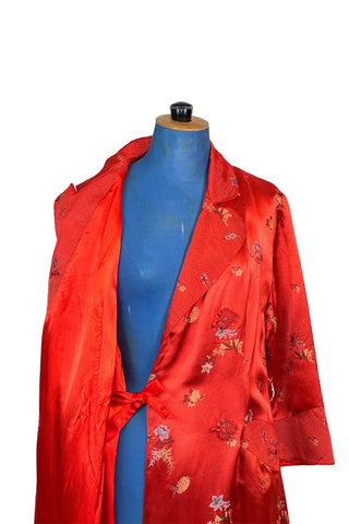 Vintage 1950s robe in rich, heavy rayon Chinese brocade. The collar, cuffs, and pockets are intricately quilted, which adds beautiful structure and weight in those areas. Closes in the front with two frog closures, and ties with a matching sash belt. Fully lined in silky red rayon.  