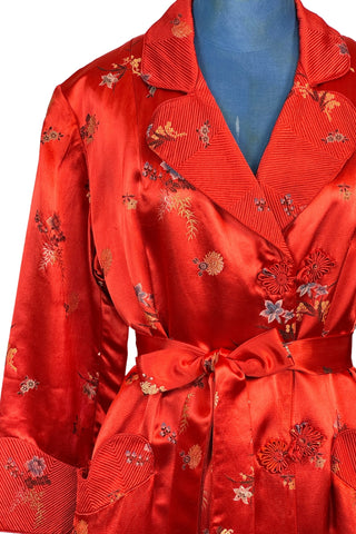 Vintage 1950s robe in rich, heavy rayon Chinese brocade. The collar, cuffs, and pockets are intricately quilted, which adds beautiful structure and weight in those areas. Closes in the front with two frog closures, and ties with a matching sash belt. Fully lined in silky red rayon.  