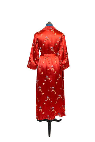 Vintage 1950s robe in rich, heavy rayon Chinese brocade. The collar, cuffs, and pockets are intricately quilted, which adds beautiful structure and weight in those areas. Closes in the front with two frog closures, and ties with a matching sash belt. Fully lined in silky red rayon.  