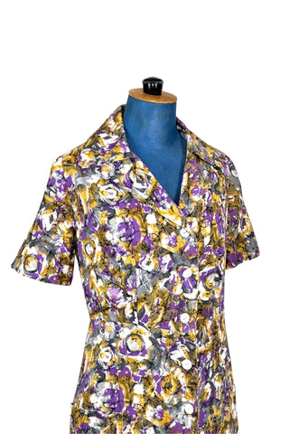 Lovely vintage day dress in abstract purple and yellow floral. Closes with nine white buttons down the front. The medium-weight cotton fabric has a subtle ribbed texture.