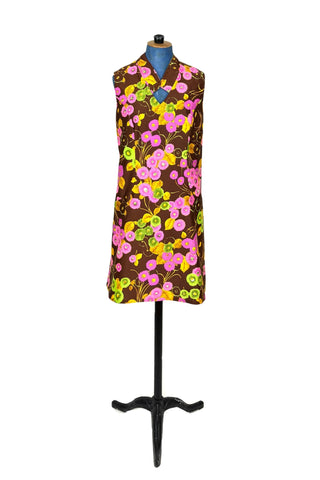 Bright and bold vintage 1960s shift dress with modified mandarin collar V-neck in psychedelic pink, green, and yellow flower print. Interesting half princess seam construction shapes the dress through the torso, then swoops out towards the hips. Closes in the back with a zipper.