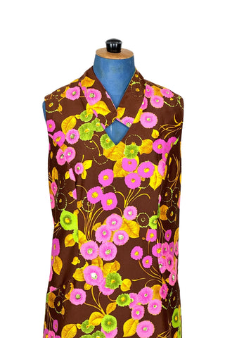 Bright and bold vintage 1960s shift dress with modified mandarin collar V-neck in psychedelic pink, green, and yellow flower print. Interesting half princess seam construction shapes the dress through the torso, then swoops out towards the hips. Closes in the back with a zipper.