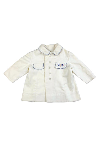 Sweet little vintage 1960s children’s coat in cream wool, with striped blue and white piping along the Peter Pan collar and decorative pocket flaps. The left pocket is embroidered with a Moroccan Berber motif.