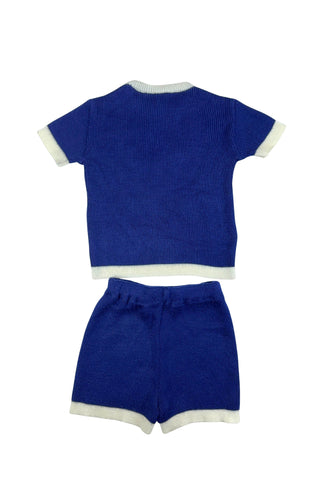 Vintage 1960s children’s knit set of short sleeve sweater and elastic waist shorts. The collar, cuffs, and hems of the sweater and shorts have a contrasting cream band.
The sweater is marked size 4, while the shorts are size 6.