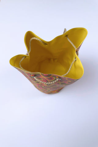 Cute little vintage 1960s waterproof bag for the beach or poolside. The tube-shaped bag closes with a drawstring cord which goes through grommets in the top and bottom of the bag.