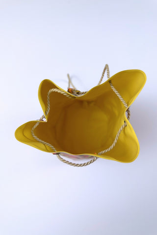 Cute little vintage 1960s waterproof bag for the beach or poolside. The tube-shaped bag closes with a drawstring cord which goes through grommets in the top and bottom of the bag.