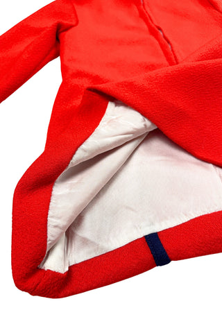 Vintage 1970s children’s dress with red skirt and sleeves, white bodice, and red pointed collar and matching pocket. The bodice and skirt feature contrasting navy blue stripes vertically and horizontally. Three decorative buttons at the neck finish this perfect late-mod look. The dress closes with a metal zipper in the back, and is fully lined in dove grey rayon.