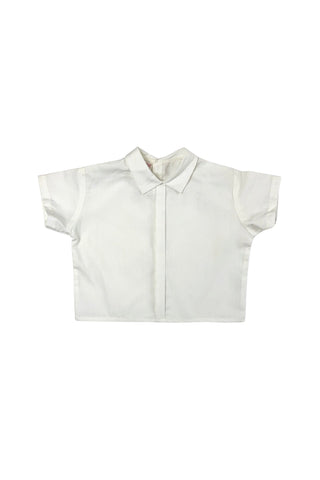 Vintage toddler’s two piece set of embroidered yellow overalls and crisp white blouse. The bib of the overalls is decorated with red, green, and yellow rickrack trim, and an embroidered scene with two tiny people wearing lederhosen outfits. The overalls have adjustable straps with two sets of buttons for two length options. The back of the waist is elasticized. The white blouse has a small pointed collar, a decorative folded faux-placket down the front, and closes with three buttons in the back.