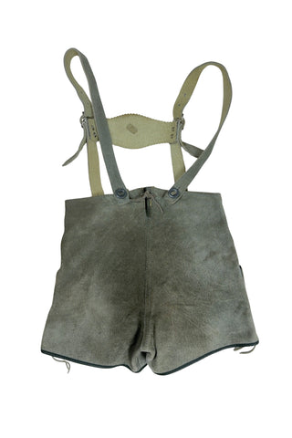 Vintage 1960s boys’ lederhosen in grey leather suede, with white scalloped suede trim, black leather accents and red suede piping.
The straps have metal buckle closures at the chest, and attach to the shorts with buttons (the shorts may be worn without straps). The front of the shorts has a flap that closes with two buttons at the waist.
In good vintage condition, with normal wear to the suede consistent with age. The inside of the front panel has a faux leather (vinyl) lining, where the vinyl has...