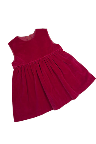 Vintage red velvet baby dress with a belted back. Sleeveless, with a simple round neckline. The high, gathered waist is trimmed with matching red piping. The thick cotton velvet dress has a fully lined bodice and unlined skirt.