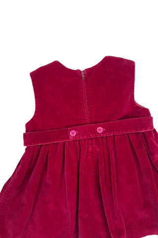 Vintage red velvet baby dress with a belted back. Sleeveless, with a simple round neckline. The high, gathered waist is trimmed with matching red piping. The thick cotton velvet dress has a fully lined bodice and unlined skirt.