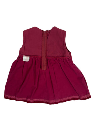 Vintage red velvet baby dress with a belted back. Sleeveless, with a simple round neckline. The high, gathered waist is trimmed with matching red piping. The thick cotton velvet dress has a fully lined bodice and unlined skirt.