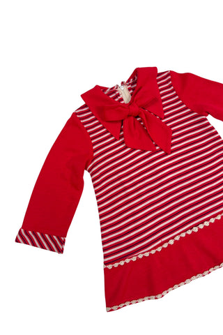 Vintage 1970s toddler dress in red, white, and black striped jersey, with a large pointed collar and oversized bow tie. The long sleeves, collar, and bottom panel of the skirt are solid red. The skirt is trimmed with daisy chain lace.

Crafted from a cotton/acrylic blend. The dress is unlined, and closes in the back with a cotton twill zipper.

Marked size 18 (months).