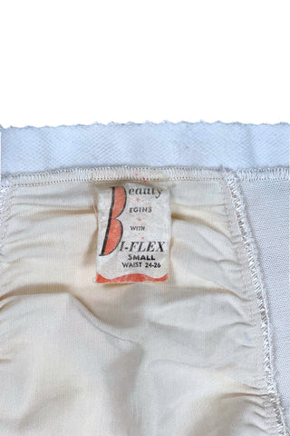 Vintage 1950s Bi-flex girdle shorts shaper garment with integrated stocking garters.

Crafted from mixed synthetic fabrics with a cotton smoother panel in the front to provide structure.

Inside the leg openings are stocking garter clips (hidden inside so that they don’t spoil the line of the garment).

The perfect base for all your true vintage or vintage inspired looks.

Designed by Bi-flex in Montreal, Canada.