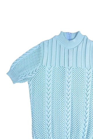 Vintage 1960s/1970s short sleeve sweater with an open eyelet knit pattern with vertical chevron panels and ribbed cuffs and collar. The back has a half-zipper closure. The material composition feels like a cotton/acrylic blend.