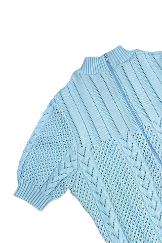 Vintage 1960s/1970s short sleeve sweater with an open eyelet knit pattern with vertical chevron panels and ribbed cuffs and collar. The back has a half-zipper closure. The material composition feels like a cotton/acrylic blend.