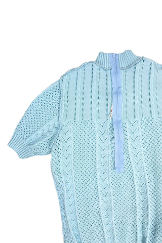 Vintage 1960s/1970s short sleeve sweater with an open eyelet knit pattern with vertical chevron panels and ribbed cuffs and collar. The back has a half-zipper closure. The material composition feels like a cotton/acrylic blend.