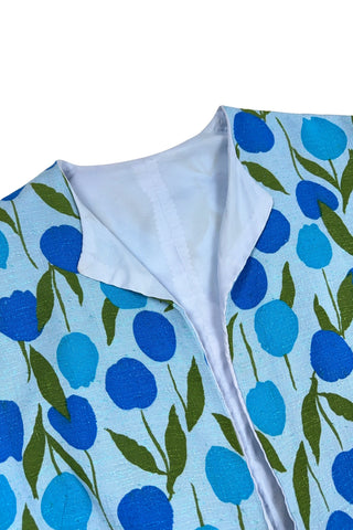 Vintage 1960s jacket in light blue cotton slub with a large tulip print. Features three-quarter length kimono-style sleeves, and an open front. Long darts from the bust to the waist provide shape through the torso. 

The lightweight jacket is lined in coordinating light blue rayon, which peeks through at the collar.