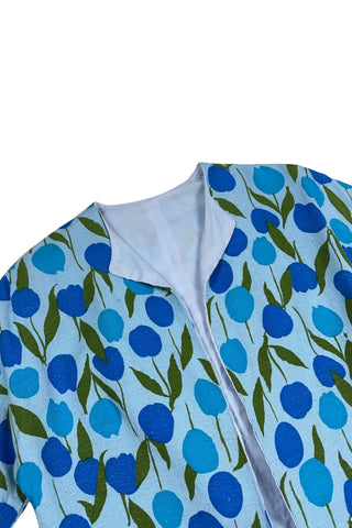 Vintage 1960s jacket in light blue cotton slub with a large tulip print. Features three-quarter length kimono-style sleeves, and an open front. Long darts from the bust to the waist provide shape through the torso. 

The lightweight jacket is lined in coordinating light blue rayon, which peeks through at the collar.