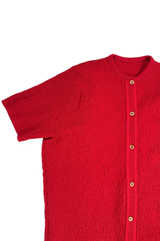 Vintage 1960s cardigan sweater in bright red ‘crazy’ textured knit (see closeup). The sweater features short sleeves with a round, ribbed collar, and a button placket with a zigzag pattern. The tight knit stitch gives the sweater a structured, weighty feel. The material feel like an acrylic blend.
