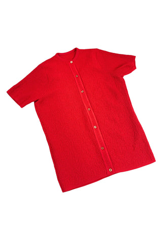 Vintage 1960s cardigan sweater in bright red ‘crazy’ textured knit (see closeup). The sweater features short sleeves with a round, ribbed collar, and a button placket with a zigzag pattern. The tight knit stitch gives the sweater a structured, weighty feel. The material feel like an acrylic blend.
