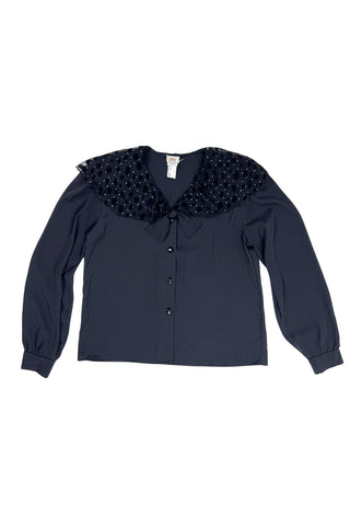 Vintage 1980s sheer black blouse with a chiffon collar featuring velvet polkadots and dots of silver sparkles. The blouse closes with four black buttons with rhinestone centres. The cuffs have matching button closures. The blouse comes with a separate tie piece that can be tied around the neck, or left off for a different look.