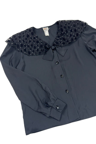 Vintage 1980s sheer black blouse with a chiffon collar featuring velvet polkadots and dots of silver sparkles. The blouse closes with four black buttons with rhinestone centres. The cuffs have matching button closures. The blouse comes with a separate tie piece that can be tied around the neck, or left off for a different look.