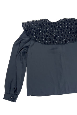 Vintage 1980s sheer black blouse with a chiffon collar featuring velvet polkadots and dots of silver sparkles. The blouse closes with four black buttons with rhinestone centres. The cuffs have matching button closures. The blouse comes with a separate tie piece that can be tied around the neck, or left off for a different look.