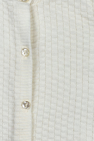 Vintage 1960s white baby sweater made of “Pure Orlon”. The bodice has a small square pattern with a slightly raised texture. The cardigan sweater closes with four pearly cateye buttons. 

Made in Canada.