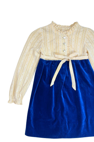 Vintage 1960s Edwardian-inspired toddler dress in rich blue cotton velvet and cream daisy lace. The dress features an empire waist belted with a thin matching sash which ties in a bow in the back, long sleeves with elasticized cuffs, and a round neck with ruffled collar. 

The dress closes in the back with four pearly buttons.