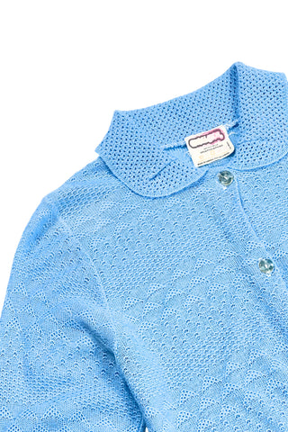Vintage 1970s blue cardigan sweater with detailed eyelet knit in a variety of different stitches. Features a Peter Pan collar, clear plastic buttons, and ribbed sleeve cuffs and waistband, similar to a sweatshirt.

Designed by Excelsior Knitting Mills. Made in Canada.