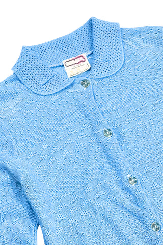 Vintage 1970s blue cardigan sweater with detailed eyelet knit in a variety of different stitches. Features a Peter Pan collar, clear plastic buttons, and ribbed sleeve cuffs and waistband, similar to a sweatshirt.

Designed by Excelsior Knitting Mills. Made in Canada.