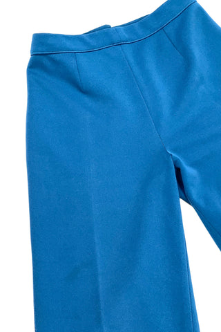 These vintage 1970s ladies’ trousers in peacock blue have the perfect true straight leg cut, providing an authentic 70s fit and flare shape when worn. The slight stretch of the medium-weight polyester fabric hugs your curves in all the right places. The trousers fasten in the back with a back zipper and self-fabric button closure. Unlined.