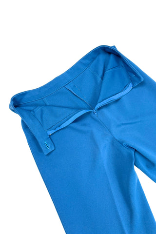 These vintage 1970s ladies’ trousers in peacock blue have the perfect true straight leg cut, providing an authentic 70s fit and flare shape when worn. The slight stretch of the medium-weight polyester fabric hugs your curves in all the right places. The trousers fasten in the back with a back zipper and self-fabric button closure. Unlined.