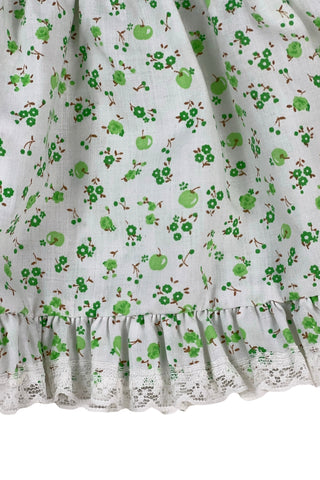 Vintage 1970s baby dress set of apron dress and bloomers with green apple blossom print. The top and hem of the apron, as well as the leg openings of the bloomers, are trimmed with tiny white lace.

Marked size 18. 65% polyester, 35% cotton.